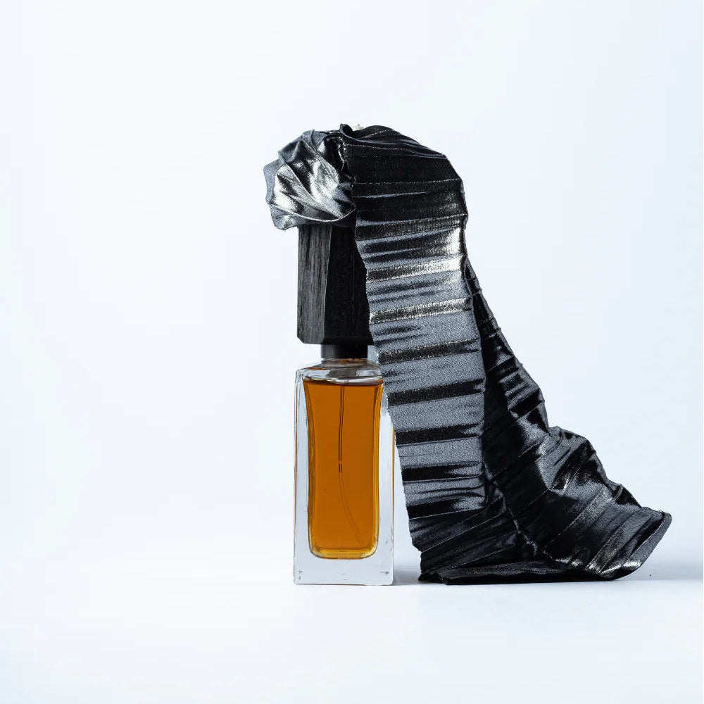 Perfume bottle with decorative black and silver packaging on a white background