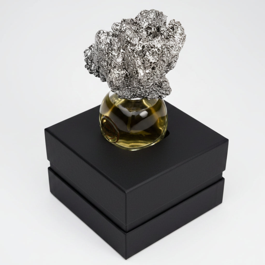 Decorative object with a textured top and glass base on a black geometric stand.