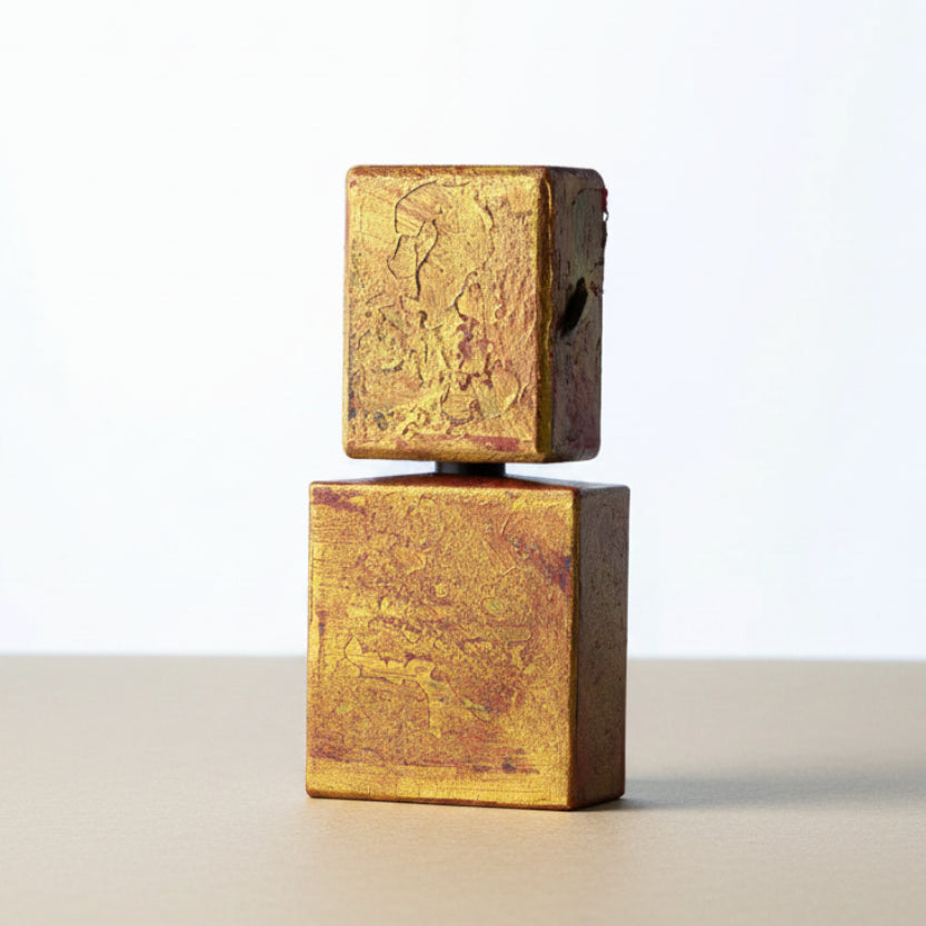 Two gold-colored square blocks stacked on a white background