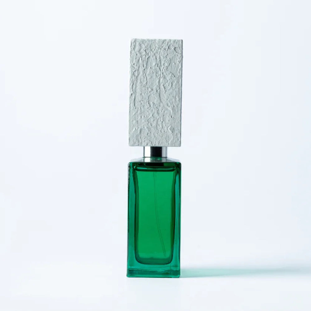 A rectangular green glass bottle with a textured light gray cap, centered on a clean white background.