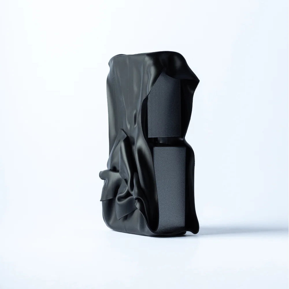 Black ceramic vase with unique design on a white background