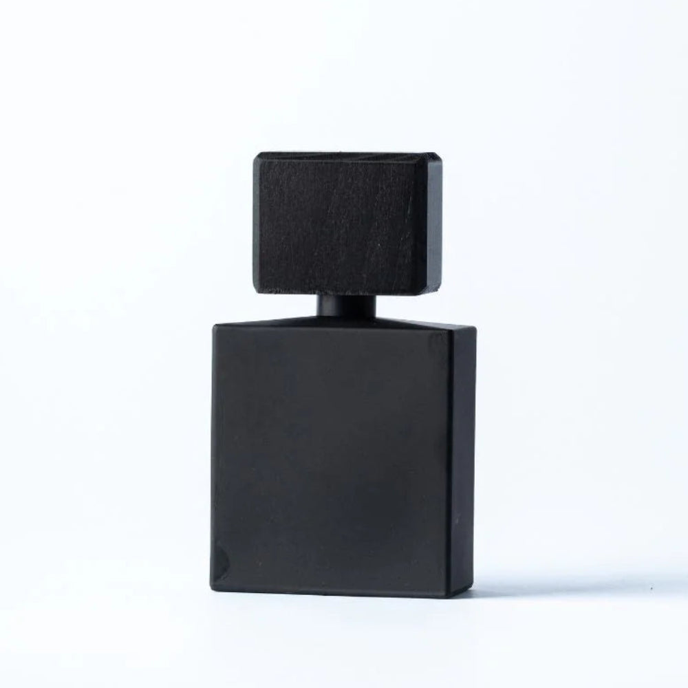 A minimalist black rectangular perfume bottle with a matching square cap, centered on a clean white background.